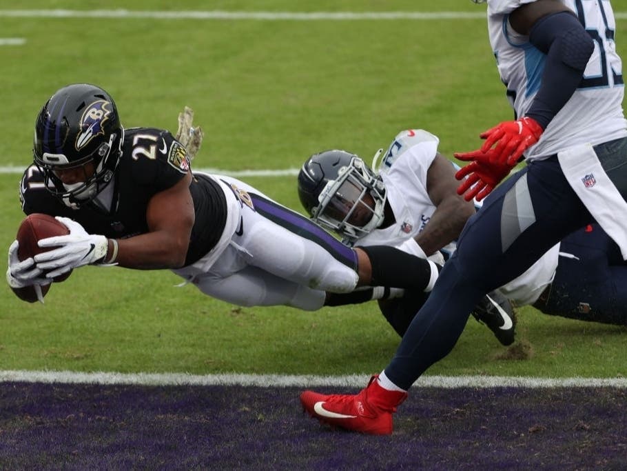 Running back J.K. Dobbins #27 of the Baltimore Ravens scores a two-point conversion against the Tennessee Titans during the first half at M&T Bank Stadium on Nov. 22 in Baltimore. He later tested positive for the coronavirus, officials said.