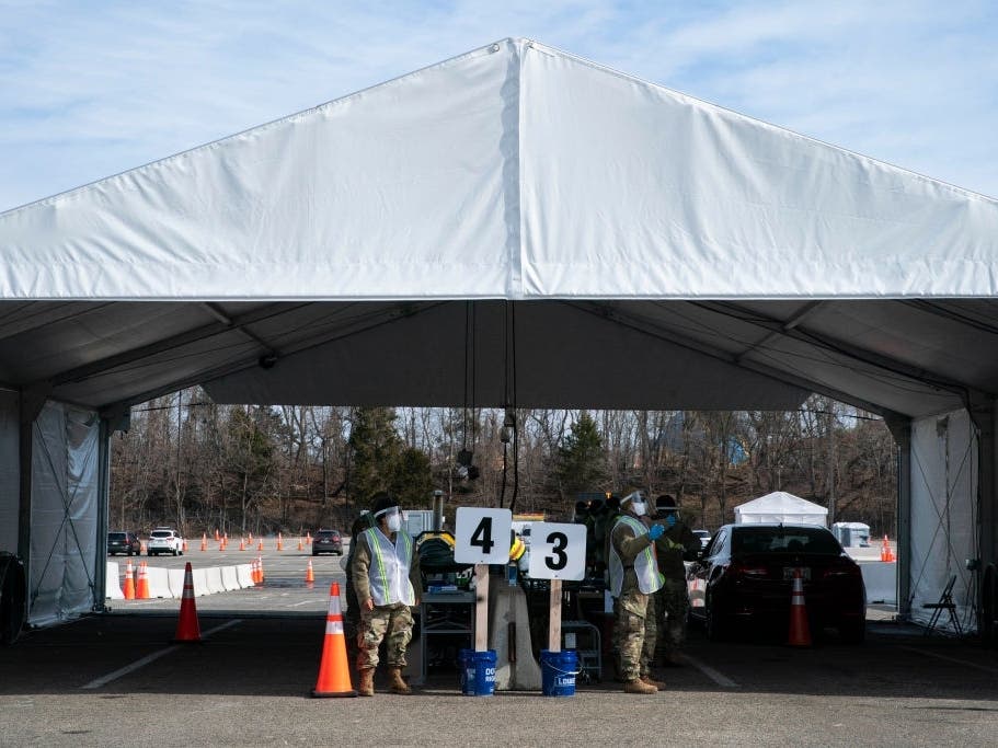 National Guard members direct cars at a mass vaccination site in the parking lot of Six Flags in Prince George's County.