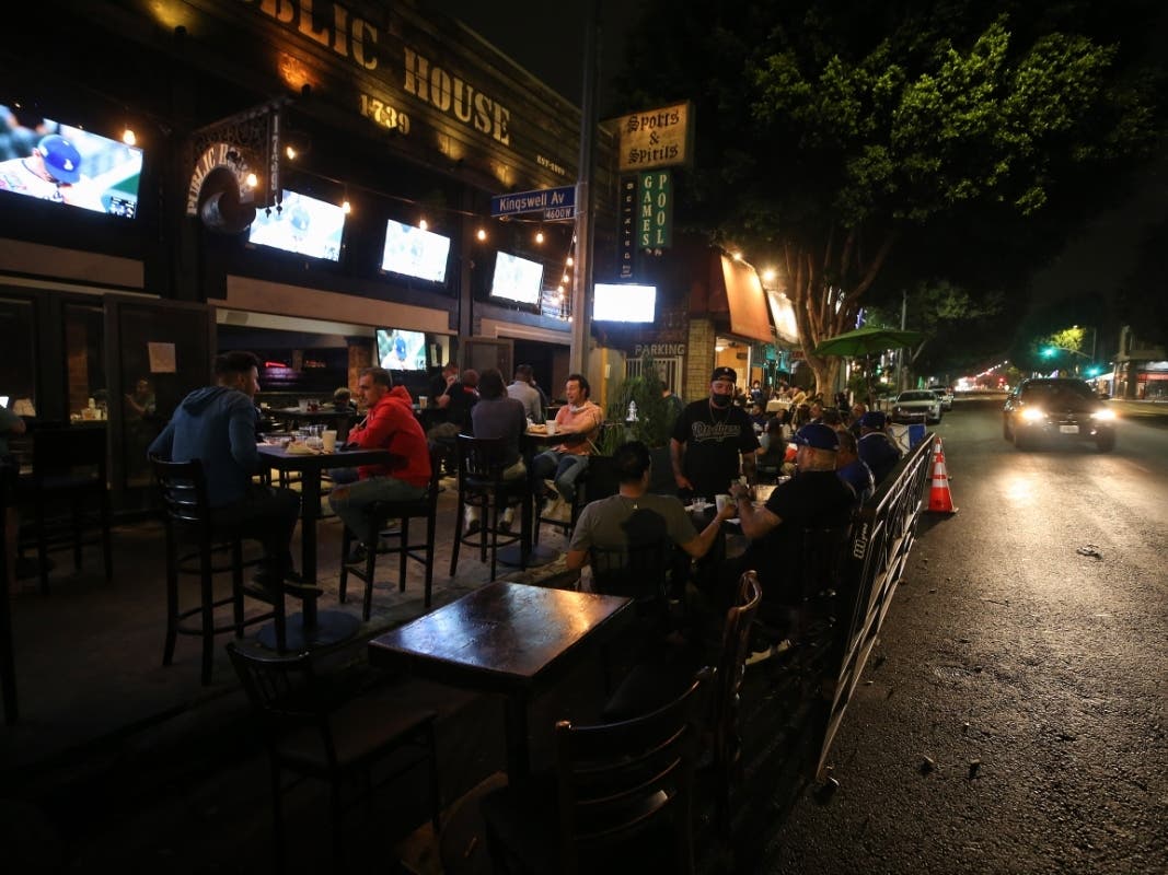 People gather to view a television broadcast of Game 1 of the 2020 World Series between the Los Angeles Dodgers and the Tampa Bay Rays at an outdoor bar and restaurant, with seating on the street due to COVID-19, on October 20, 2020 in Los Angeles