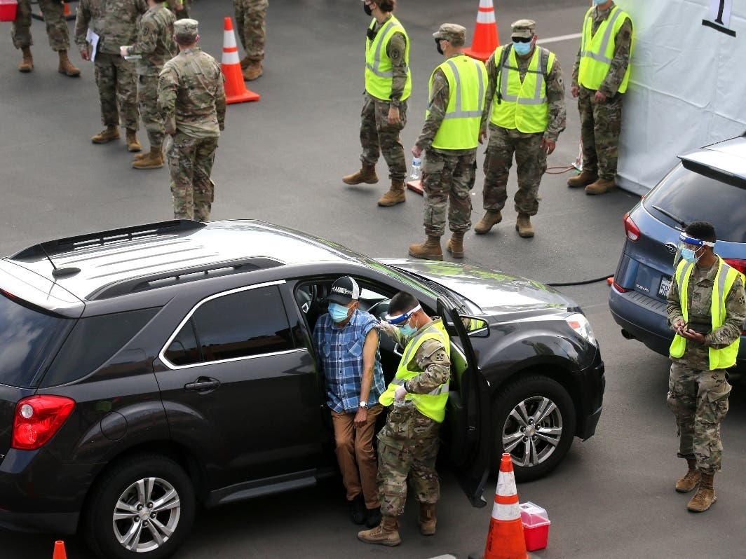 A person is vaccinated by a member of the National Guard at a new large scale COVID-19 vaccination site at Cal State Los Angeles on February 16, 2021.