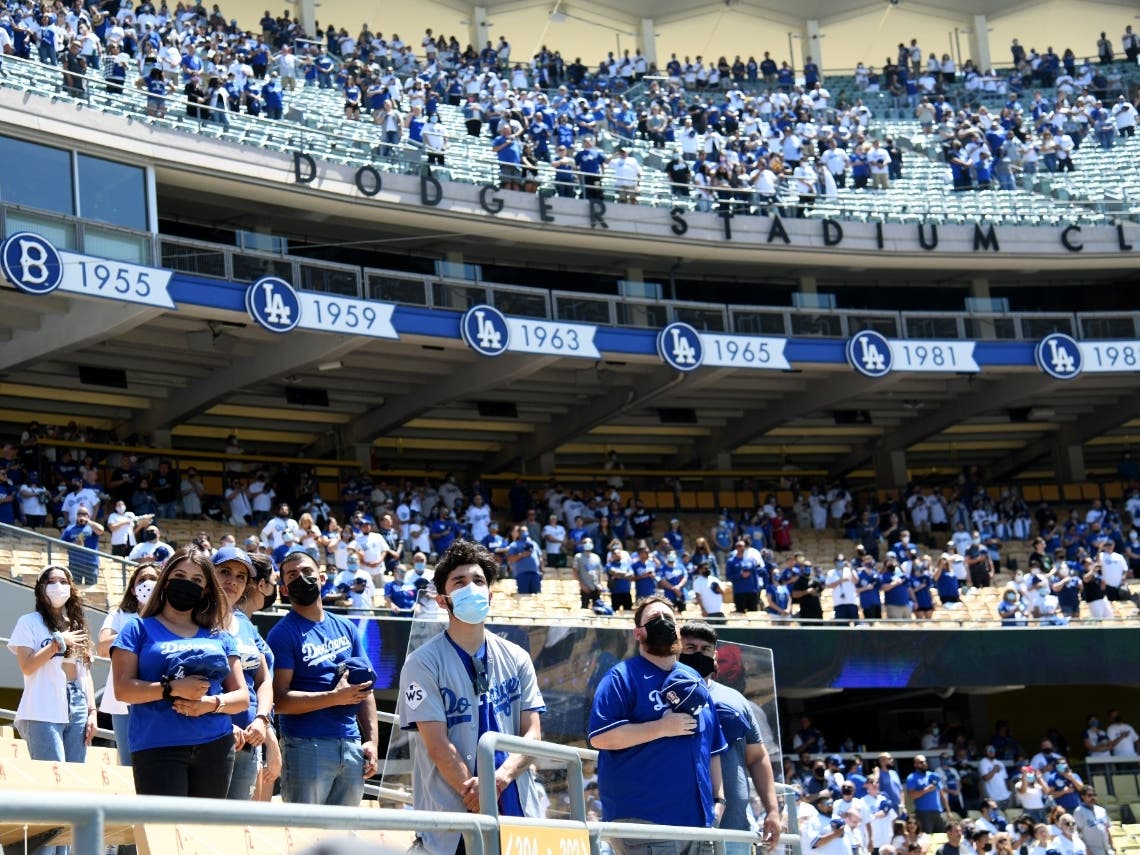 LOS ANGELES, CALIFORNIA - APRIL 09: Fans stand for the National Anthem before the game between the Washington Nationals and the Los Angeles Dodgers during the 2021 MLB season home opening game at Dodger Stadium on April 09, 2021 in Los Angeles