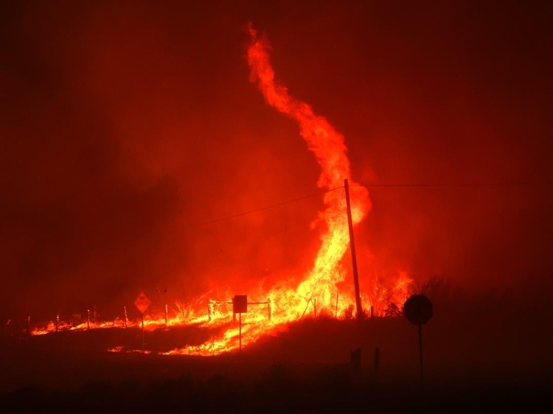 A fire whirl kicks up as the Dixie fire burns through the area on Monday near Janesville.