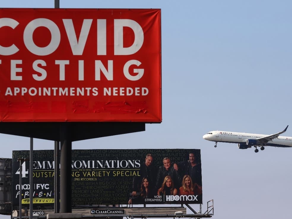 A Delta Air Lines plane lands near a COVID-19 testing sign at Los Angeles International Airport (LAX) on August 25, 2021.