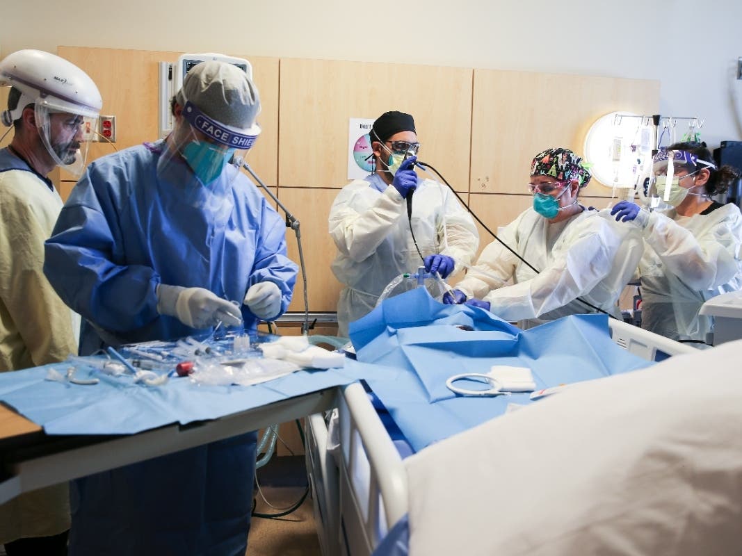 Clinicians perform a tracheostomy on a patient in a COVID-19 ICU (Intensive Care Unit) at Providence Holy Cross Medical Center in the Mission Hills neighborhood.