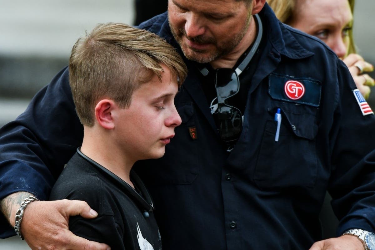 A parent comforts his son after a school shooting in Highlands Ranch, Colorado, left one student dead and eight injured.