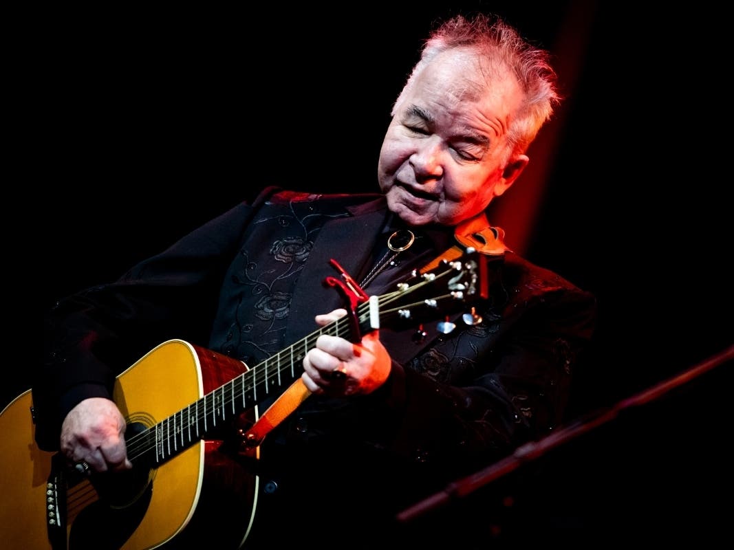 John Prine, shown performing in October at John Anson Ford Amphitheatre in Hollywood, California, is critically ill after being infected with the new coronavirus, his family said.