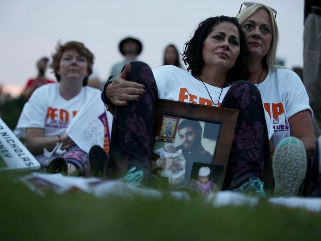 Activists hold a vigil in Washington, D.C., to raise awareness about opioid dangers. Terri Zaccone (2nd R) of New Port Richey, Florida, is comforted by sister Tina Rhatigan (R), as she holds a picture of her son Thomas DeVito who died from carfentanil.