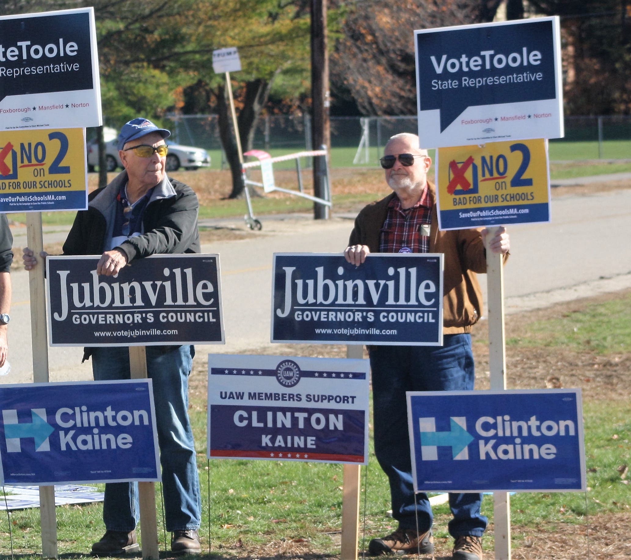 Arthur Muldoon and Ray Webb hold signs outside of the Ahern Middle School