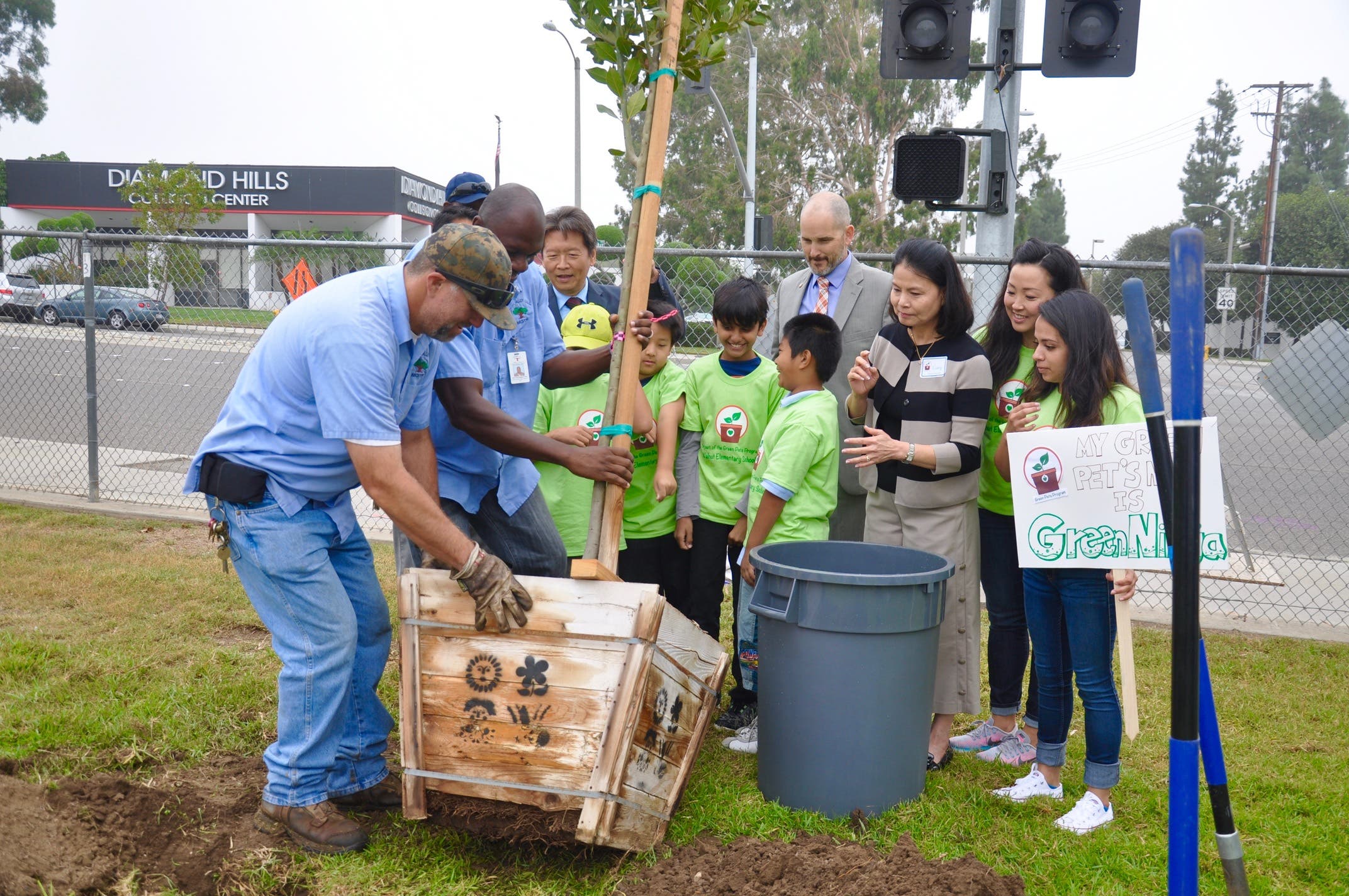 Grounds workers Paul LeBrun and Noel Foly demonstrate tree planting at Walnut Elementary.