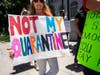 A protester holds a placard that says not my quarantine during a rally outside the Los Angeles City Hall to protest the Stay at Home Orders that were put in place due to the coronavirus pandemic on May 25, 2020..