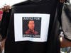 A demonstrator holds a T-shirt showing a portrait Of George Floyd.