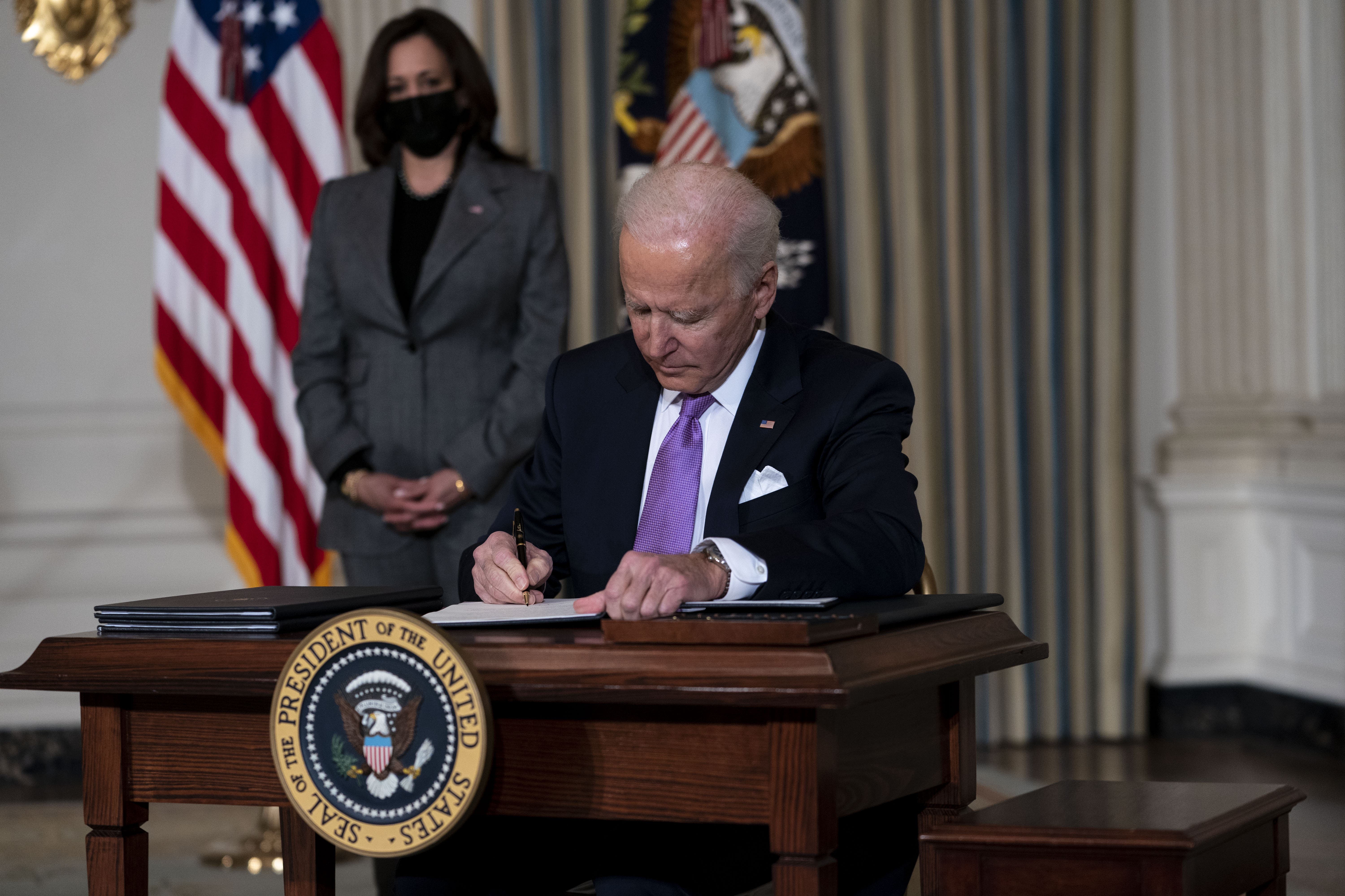 President Joe Biden signs an executive order with Vice President Kamala Harris at this side after delivering remarks outlining his racial equity agenda on Jan. 26 at the White House. (Shutterstock)