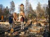 Homeowners in March 2019 look at the remnants of a burned home in Paradise, California after the Camp Fire that occurred in November 2018.