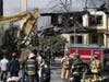 Firefighters sifted through rubble with a bulldozer after a fire broke out at Evergreen Court Home for Adults in Spring Valley, New York March 23, 2021. A resident and a firefighter died and more than a dozen people were injured.