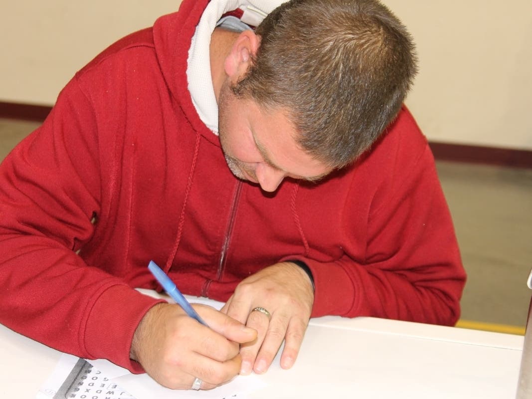 A St. Coletta's participant signs a Thank You card for one of the many DSPs that work in his residential home. 