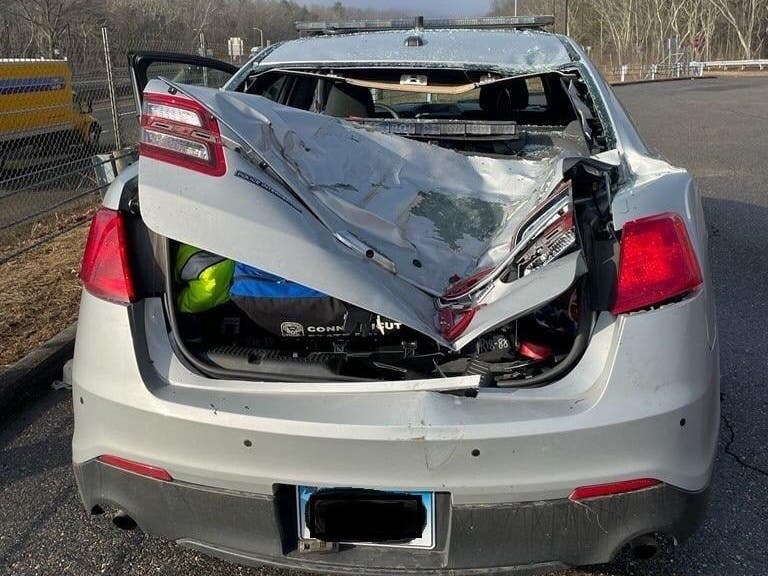 Wayward truck tires slammed into a parked state police cruiser on Interstate 84 Friday. 