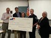 Manchester Road Race officials present a check for $7,800 to Hartford Interval House during ceremonies at the Manchester Police Department headquarters. The donation was made possible by runners who participated in the race's honors club program.