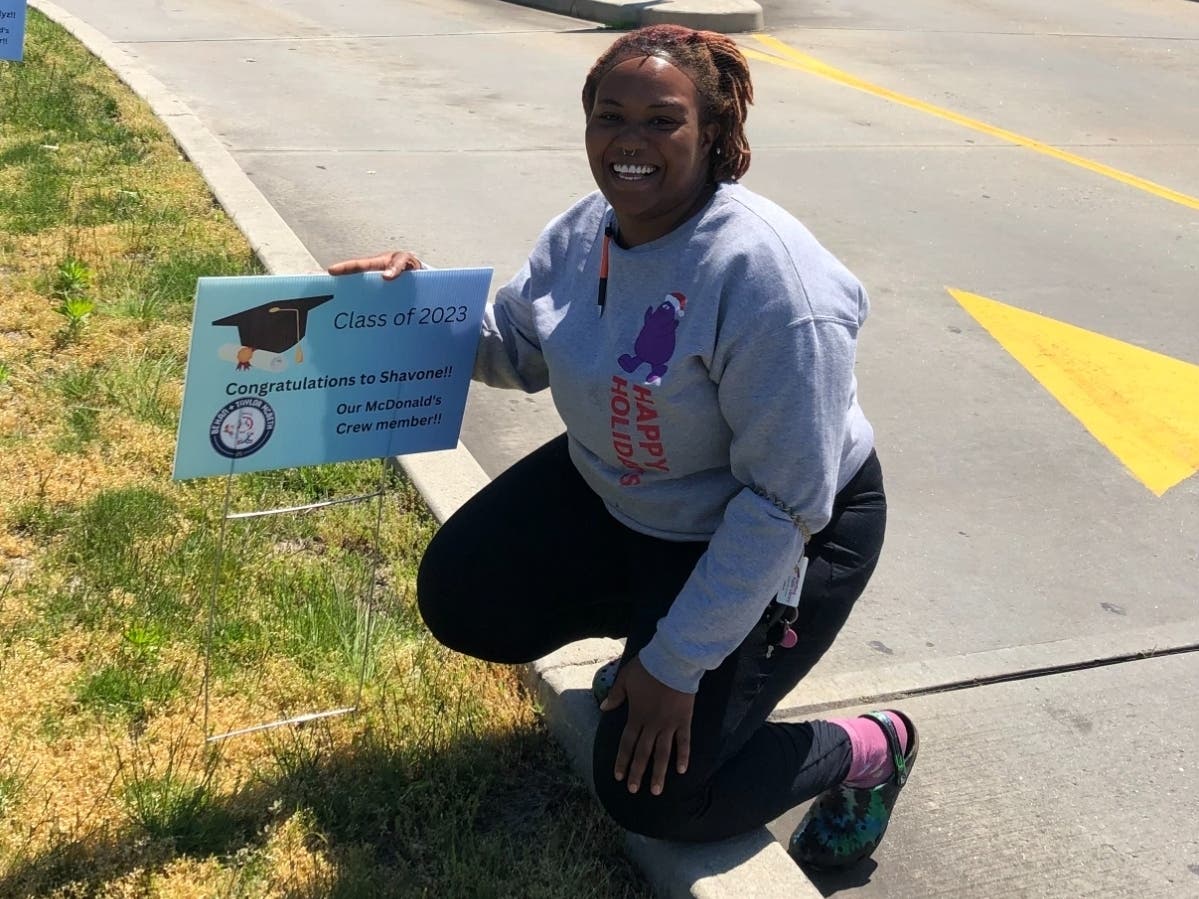 Shavone Watson poses next to her graduation sign posted by the local McDonald's, where she took advantage of a program to obtain her GED. 