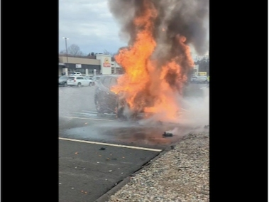 A car burst into flames with a slight explosion in a Manchester parking lot Monday. 