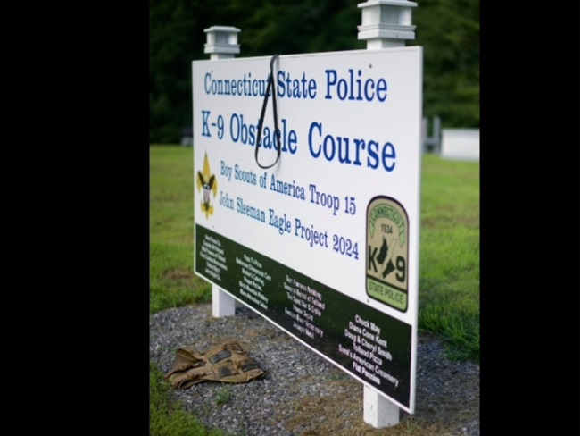 Canine Drago's vest and leash Tuesday were placed at the sign of the new canine obstacle and training course as a last testament to the late police dog. 