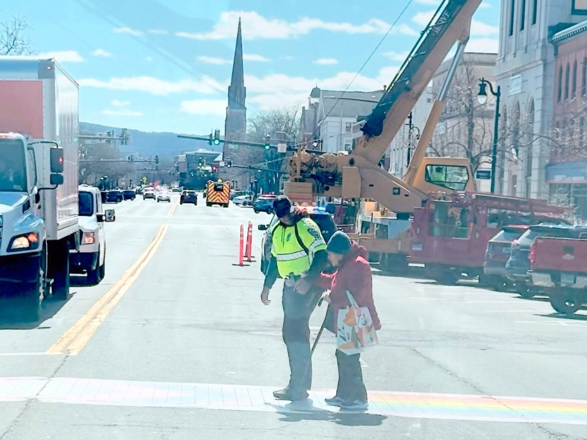 Officer Raeshaun Finney took a few extra seconds from a detail on Main Street to help an elderly resident safely cross the street Tuesday.