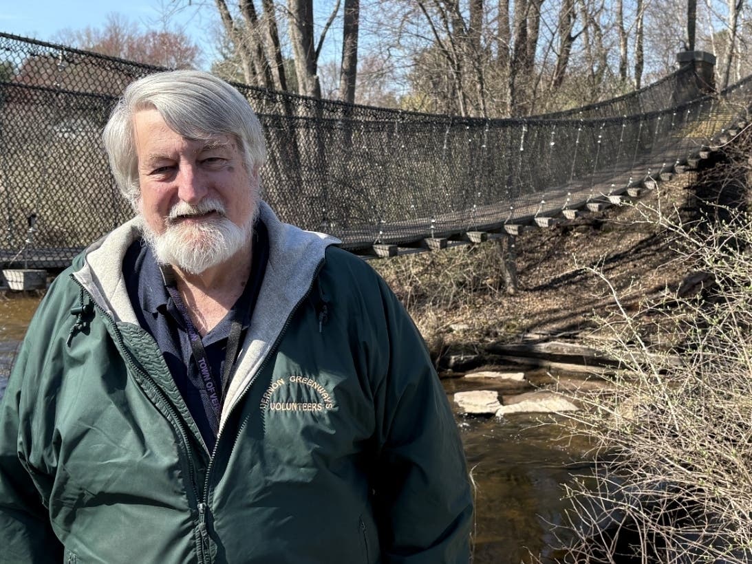 Retired Vernon town engineer David Smith next to the suspension bridge that carries the Hockanum River Linear Park trail across the river north of Windsorville Road, one of his favorite projects. 