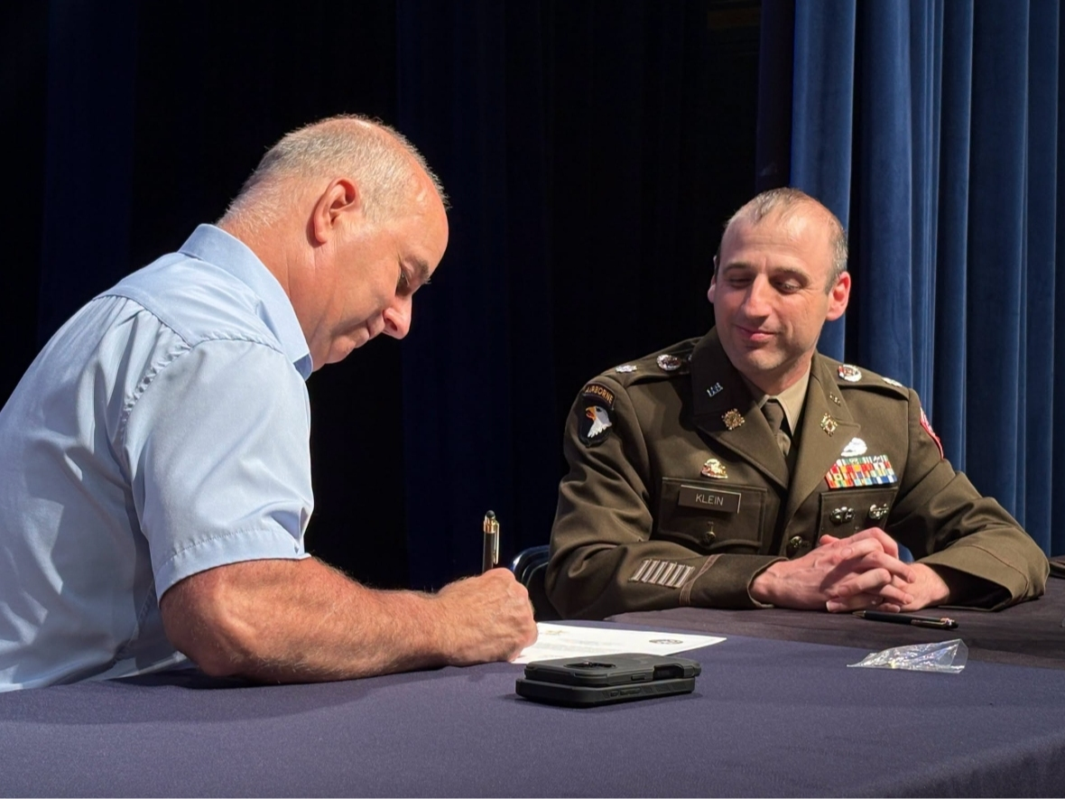 Mayor Dan Champagne and Army Lt. Col. Micah Klein sign an agreement aimed at helping veterans connect with jobs in town government.