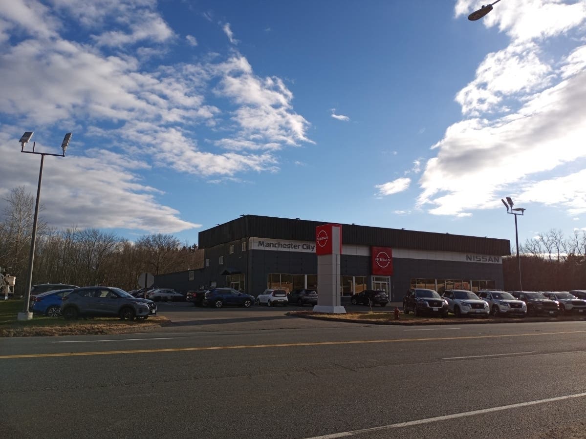 Owners of the former Manchester Nissan dealership are to pay $4 million in a case involving accusations of junk fees, deceptive practices. It now has a new sign under the Bertera flag. 