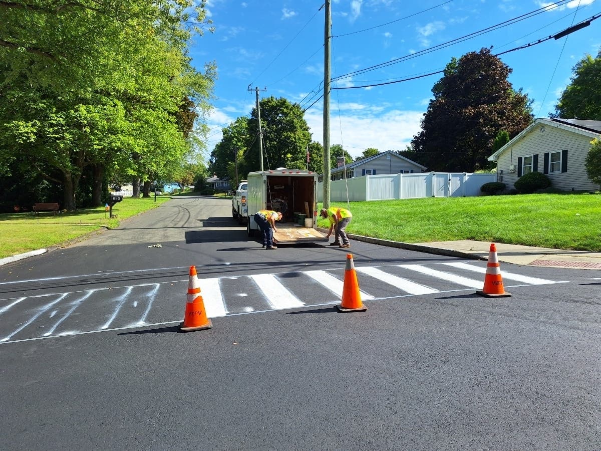 A Vernon DPW crew Wednesday works on a temporary crosswalk at the intersection of Center Road and Crestridge Drive in anticipation of Thursday's opening day for the 2026-27 academic year. Permanent ones will be done next week. 