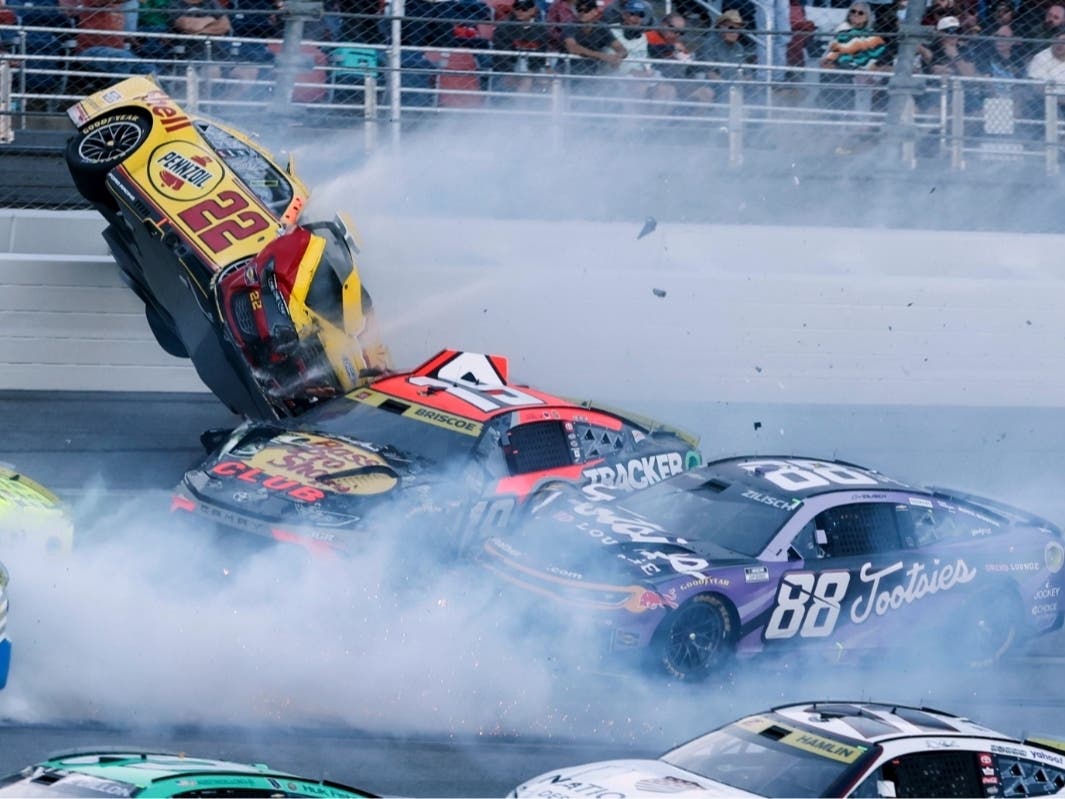 Joey Logano (22) flips after wrecking with Chase Briscoe (19) and involving multiple drivers in the tri-oval during a NASCAR Cup Series auto race Sunday in Talladega, Ala.