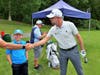 Cooper King, 10, of Ellington looks on as PGA TOUR player Robert Garrigus shakes hands with Cooper's dad, Tim.