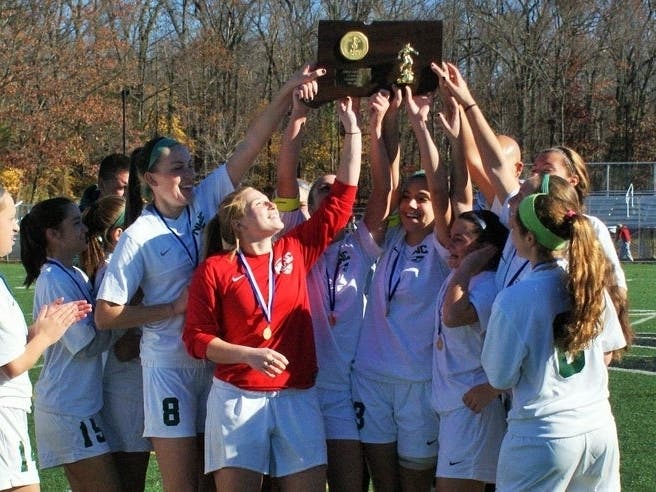 Northwest Catholic players celebrate their victory in the 2015 Class M girls soccer finals.