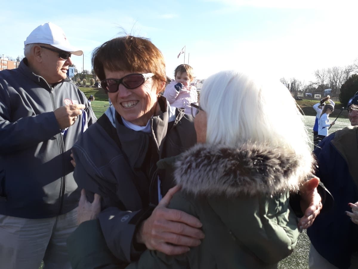 Guilford field hockey coach Kitty Palmer is embraced by the legendary Cookie Bromage after the Indians won their second straight Class M title.
