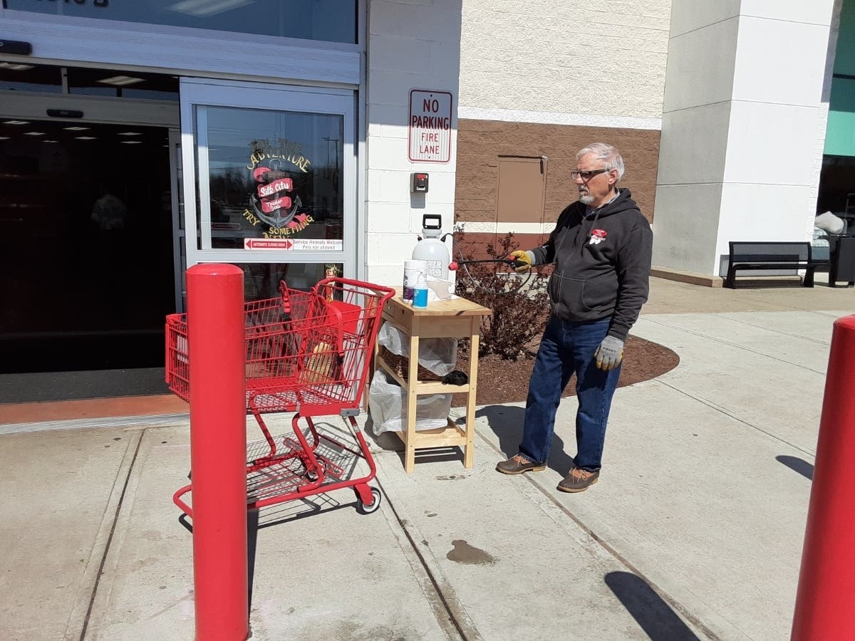 An employee of Trader Joe's in Manchester sanitizes carts in front of the store.