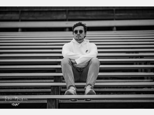 Jacob Mongeon in the bleachers at the Farmington High School athletic complex.