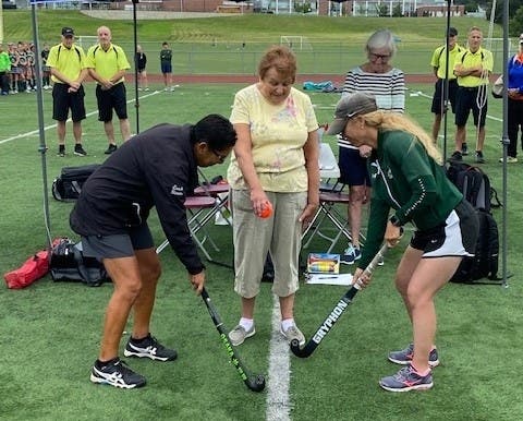 Amy Romano's mom Judie drops the ceremonial opening ball between Longmeadow coach Ann Simons and Enfield coach Amy Bartholomew.