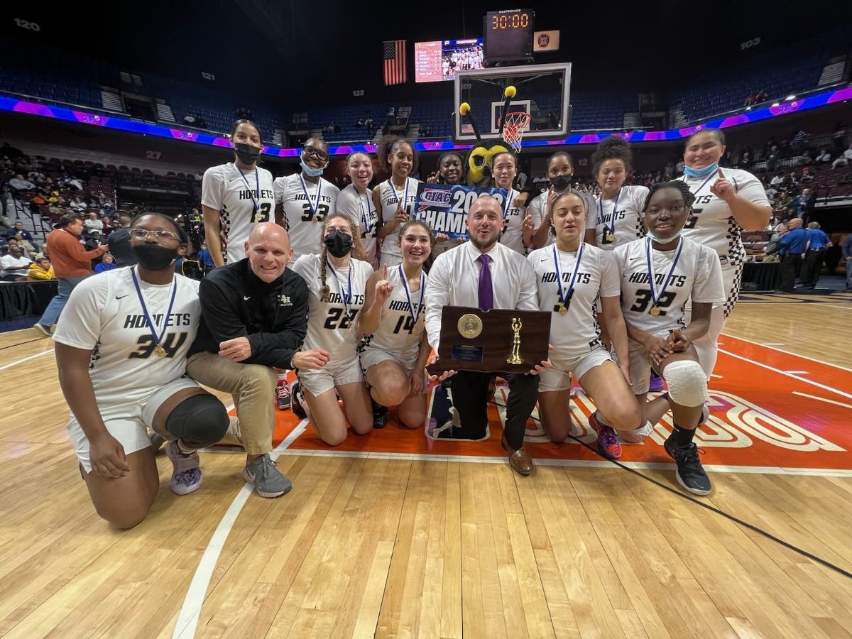 A jubilant East Hartford squad celebrates the program's first girls basketball state championship.