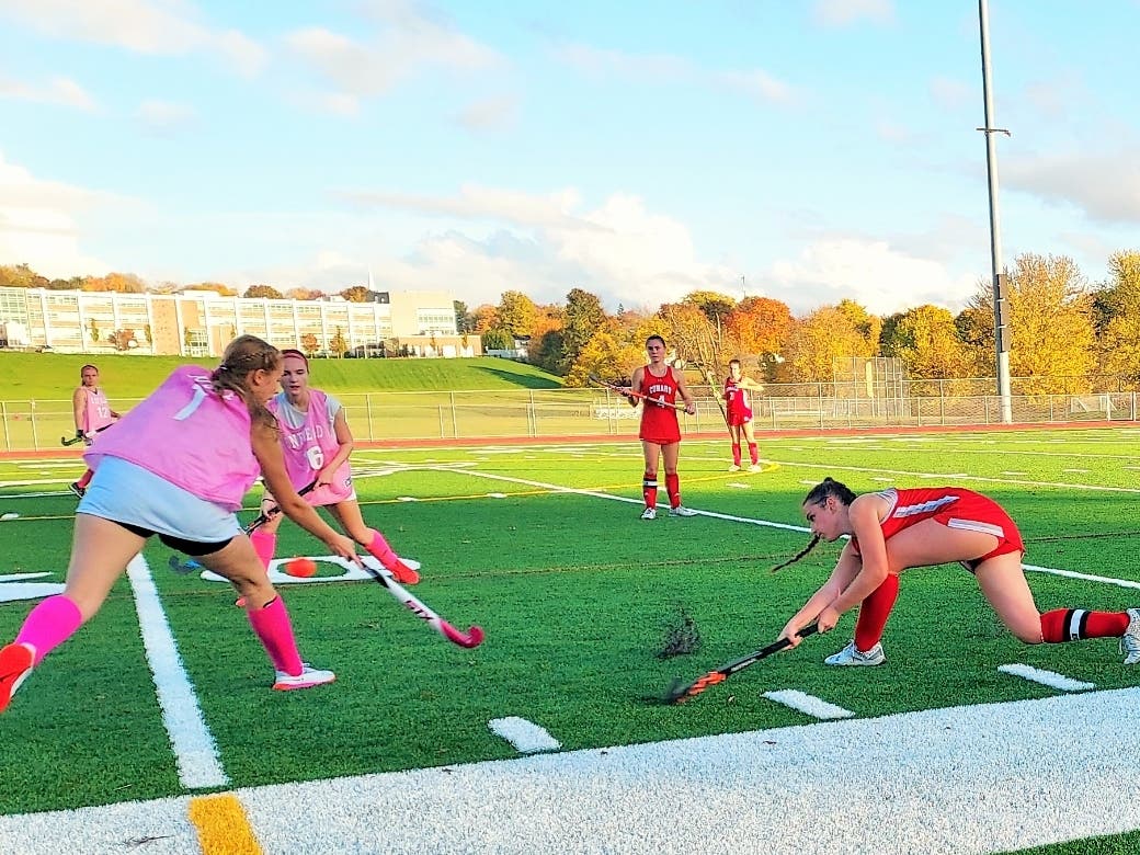 Kate Parker of Conard drives the ball past Enfield defenders Ella Kusta and Olivia Castagno during field hockey action Tuesday.
