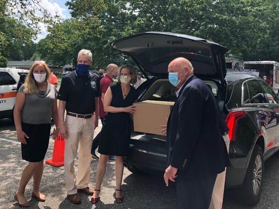 Nassau County Executive Laura Curran (center) and County Legislator Delia DeRiggi-Whitton (left) help load PPE kits onto vehicles for delivery to small businesses and nonprofits. 