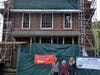 (From left) NSHM member Millie DeRiggi, Grant Writer Georgie Connett and Legislator DeRiggi-Whitton in front of the construction being done to the façade of the North Shore Historical Museum.
