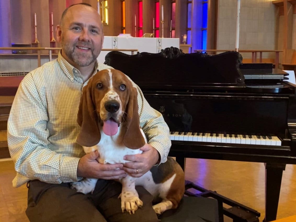 John Churchwell, newly appointed music director at All Saints and his beloved Bassett Hound Sheriff, who frequently accompanies him to church for rehearsals on the Steinway and the pipe organ.