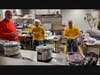 The kitchen bustling on meal day with 5 or 6 people prepping, chopping, dicing, peeling, slicing, cooking, or washing dishes prior to the big evening.  It takes more than 20 volunteers to purchase the food, prep, cook, serve, clean dishes, and bus tables.
