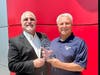 Scott Cairo (l), Nissan Senior Operations Manager, presents Paul Miller with a 30th Anniversary Award commemorating 30 years as a Nissan Dealer.