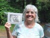Lorraine Wetstone picks up her Event Sketch of "Leo" that she won from Portraits by ShawnaLee's booth at the Catherine Violet Hubbard Sanctuary's 2024 Butterfly Party in Newtown CT.