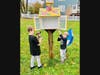 East Dedham resident Nick Garlick got assistance from his sons to reinstall the newly refurbished little library at Whiting Park. 