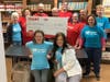 Giant employees (in the red shirts) and Warminster Food Bank volunteers (in the blue shirts) take a break from their work to pose with a $10,000 check from Giant Supermarket of Warminster to the Warminster Food Bank.