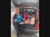 Warminster Food Bank volunteer Renee Hrin Solt picks up some of the food collected by Shir Ami Reform Synagogue of Newtown. The items will be used to make monthly grocery bags for Warminster Food Bank guests.