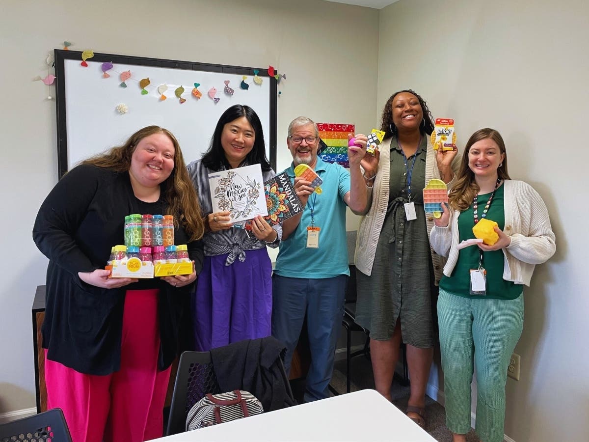 NOVA Counselors Sydney Finsel, Jee Soo Lee, Kevin Keller, Ray'ven Hudley, and Beth Haff pose with some of the comfort items that were donated by the Danaher Lynch Family Foundation Scholars Program and students at Our Lady of Grace Elementary School.