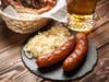 Pretzels, bratwurst and sauerkraut on wooden table