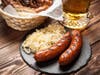 Pretzels, bratwurst and sauerkraut on wooden table
